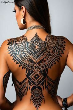 the back of a woman's body with tattoos on it