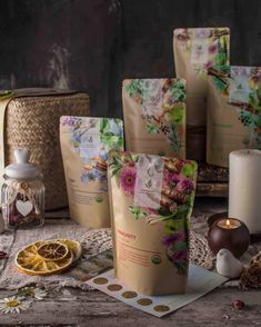 several bags of tea sitting on top of a table next to candles and other items