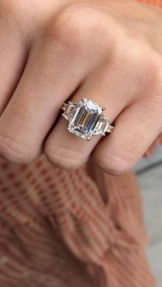 a woman's hand with an engagement ring on her finger, showing the center stone