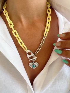 Introducing the perfect Acrylic Summer necklace for your beachy wardrobe! This unique piece features a stunning yellow acrylic chain, paired with a sleek silver aluminium chain, and finished with a gorgeous heart charm boasting a turquoise enamel stone at the center. The adjustable front connection allows you to customize the height to your liking, making it a versatile accessory for any outfit. With a length of 45 cm (17.7''), this necklace is perfect for layering or wearing solo. Keep it brigh Silver Chain Necklaces For The Beach, Silver Chain Necklace For Beach, Trendy Yellow Necklaces For Beach, Trendy Yellow Necklace For The Beach, Trendy Yellow Necklace For Beach, Beachy Wardrobe, Summer Necklace Beach, Beach Necklace, Beach Necklaces