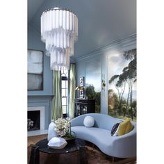 a living room filled with furniture and a chandelier hanging over the fire place