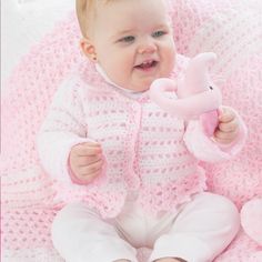 a baby is holding a pink stuffed animal