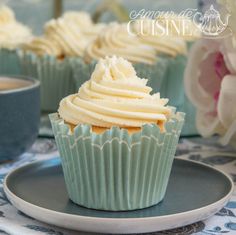 cupcakes with white frosting sitting on a plate