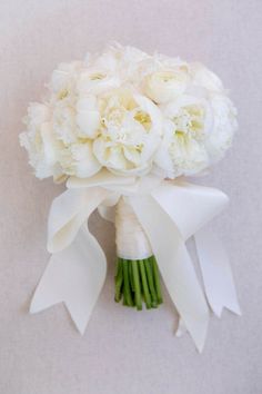 a bridal bouquet with white flowers and ribbons