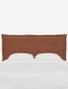 an upholstered headboard on a bed with white sheets and brown linens