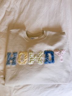 a white t - shirt with the word hod on it is laying on a bed