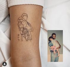 a man holding a baby in his arms with a tattoo on it's arm