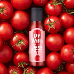 a bottle of dr will's tomato ketchup surrounded by many red tomatoes