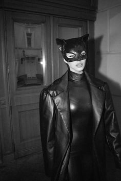 a woman wearing a cat mask and leather coat