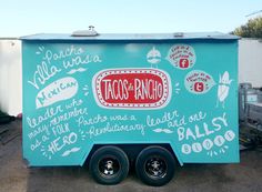 a taco truck parked in a parking lot next to other cars and trucks with writing on the side