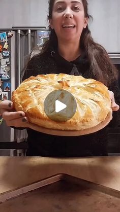 a woman holding a pie in front of her face