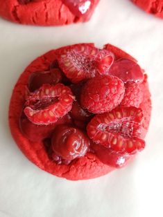 raspberry cookies are arranged on a white surface