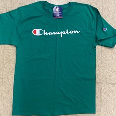 This Champion Shirt Is A Wonderful Green In Color And A Medium In Size . This Is An Irregular Stamped At Company . All The Regular Stuff Is Therr . Green Relaxed Fit Top With Logo Print, Green Short Sleeve Shirt With Logo Print, Green Logo Print Shirt For Summer, Green Logo Print Summer Shirt, Green Crew Neck Cotton Shirt, Green Cotton Crew Neck Shirt, Green Short Sleeve Top With Logo Print, Green Crew Neck Top With Text Print, Green Shirt With Text Print For Spring