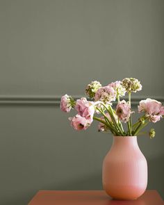 a pink vase filled with flowers on top of a table