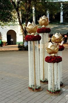 three tall white and red flowers on poles