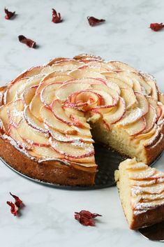 a cake that has been sliced and is sitting on a table with petals around it