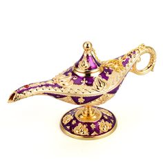 an ornate purple and gold covered teapot on a stand