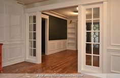 an empty room with wood floors and white walls