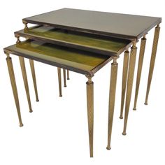 three nesting tables with metal tops and wood legs, each topped with a glass top