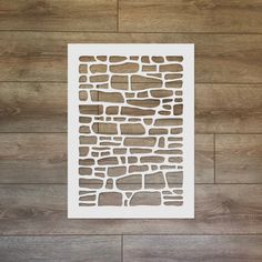 a piece of paper cut out to look like a stone wall on a wood floor