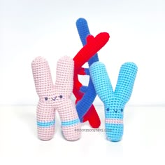 three crocheted stuffed animals sitting next to each other in front of a white background