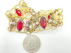 "This lovely bracelet features oval bezel set rhinestones in a deep ruby red color. The stones are flanked by white enamel flowers with red leaves that coordinate with the stones. These stones and enamel are all set in antique brass links. This wide, delicate bracelet has all the hallmarks of a Neiger piece (although these were not signed, so it's a bit hard to be sure). In any event, this is a prime example of Art Deco Czech jewelry. CONDITION/SIZE: Excellent vintage condition. About 7.5\" long Collectible Red Filigree Jewelry, Vintage Red Bracelets For Wedding, Vintage Red Bracelet For Wedding, Vintage Red Wedding Bracelet, Antique Jeweled Red Jewelry, Vintage Oval Red Jewelry, Vintage Ruby Jewelry For Parties, Red Oval Art Deco Jewelry, Vintage Red Jewelry With Stone Setting