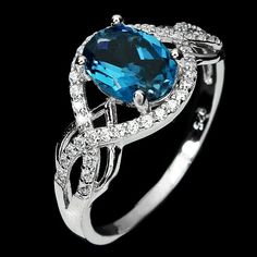 ~ Vibrant & Mystical London Blue Topaz Ring ~ Dive into the deep waters of elegance with this stunning deep sea blue topaz ring! Mounted in lustrous 18k white gold over pure sterling silver, this deep inky, oceanic blue, 1 1/2 carat gemstone creates a stunning ring. The beautiful solitaire is framed by a graceful halo of brilliant moissanites gems. The setting is lustrous 18k white gold over pure sterling silver. This is an elegant, graceful, cocktail ring, perfect for that specail event OR indu Luxury Sterling Silver Topaz Ring With Halo Setting, Luxury Solitaire Topaz Ring In Sterling Silver, Luxury Silver Topaz Ring With Halo, Luxury White Gold Topaz Ring With Moissanite, Luxury Sterling Silver Topaz Ring With Gemstone Accents, Luxury Blue Topaz Jewelry With Halo Setting, London Blue Topaz Ring, Sea Blue, London Blue Topaz