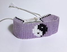 a purple beaded bracelet with a black and white dog on it's face