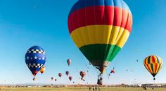 many hot air balloons are flying in the sky