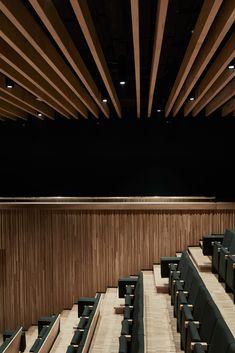 an empty auditorium with rows of seats in front of a projector screen on the wall