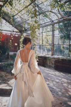 the back of a woman's wedding dress in a greenhouse