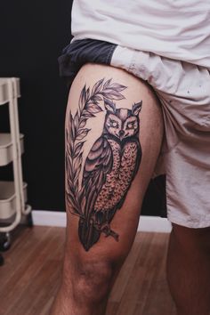 an owl tattoo on the leg of a man