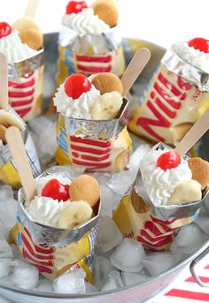 there are many desserts in the ice bucket on the table with red and white stripes