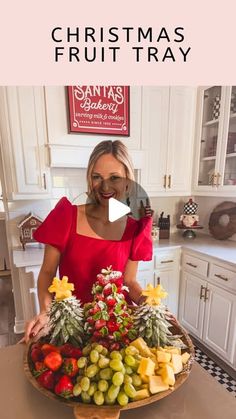 a woman standing in front of a christmas fruit tray