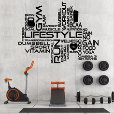 an exercise room with a stationary bike and wall decals in black, white and orange