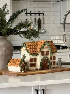 a gingerbread house on a cutting board in a kitchen