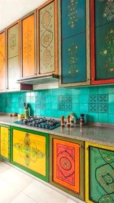 a kitchen with colorful cabinets and tile backsplashes on the counter top,