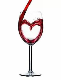 red wine being poured into a glass in the shape of a heart on a white background