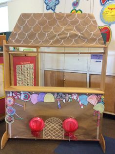 a toy ice cream stand with candy and candies on the top, in a classroom