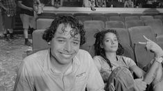 a man sitting next to a woman on top of a chair in front of an audience