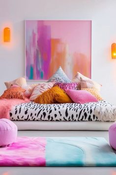 a bed with lots of pillows on top of it in front of a colorful painting