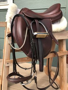 a brown horse saddle sitting on top of a wooden step