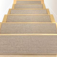 a set of beige carpeted stairs leading up to an open door with white walls