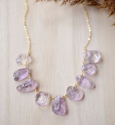 "Pale Purple Raw Amethyst Necklace Get in touch with your inner peace with Amethyst. Amethyst, the birthstone for February, is said to repel negative energies and promote calm. This necklace features natural, pale purple Amethyst crystals that have been semi-shaped into teardrops. Each stone is different in size and shape making every necklace a one of a kind. Choose to have it made in 14k gold filled or sterling silver.  GEMSTONE: Natural Amethyst STONE SIZE: Average 15-24mm (1\" and under) MET Delicate Crystal Gemstone Necklaces For Wedding, Purple Gemstone Necklace For Wedding, Delicate Crystal Gemstone Necklace For Wedding, Amethyst Necklace With Gemstone Accents For Wedding, Amethyst Necklaces For Wedding, Gold Amethyst Necklace For Wedding, Purple Faceted Jewelry For Wedding, Wedding Gold Necklace With Amethyst, Dainty Natural Stone Wedding Necklace