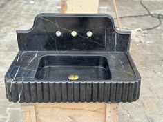 a black sink sitting on top of a wooden box