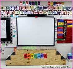 a white board sitting on top of a wooden box in front of a bulletin board