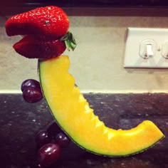 a fruit sculpture made to look like a banana and some grapes