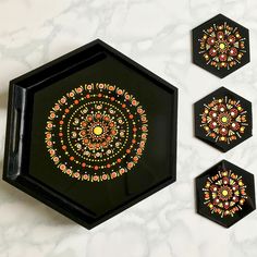 three black trays with colorful designs on them