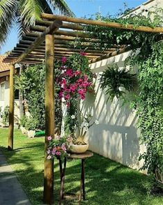 a wooden pergola with pink flowers on it