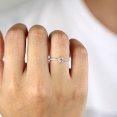 a woman's hand with a diamond ring on it